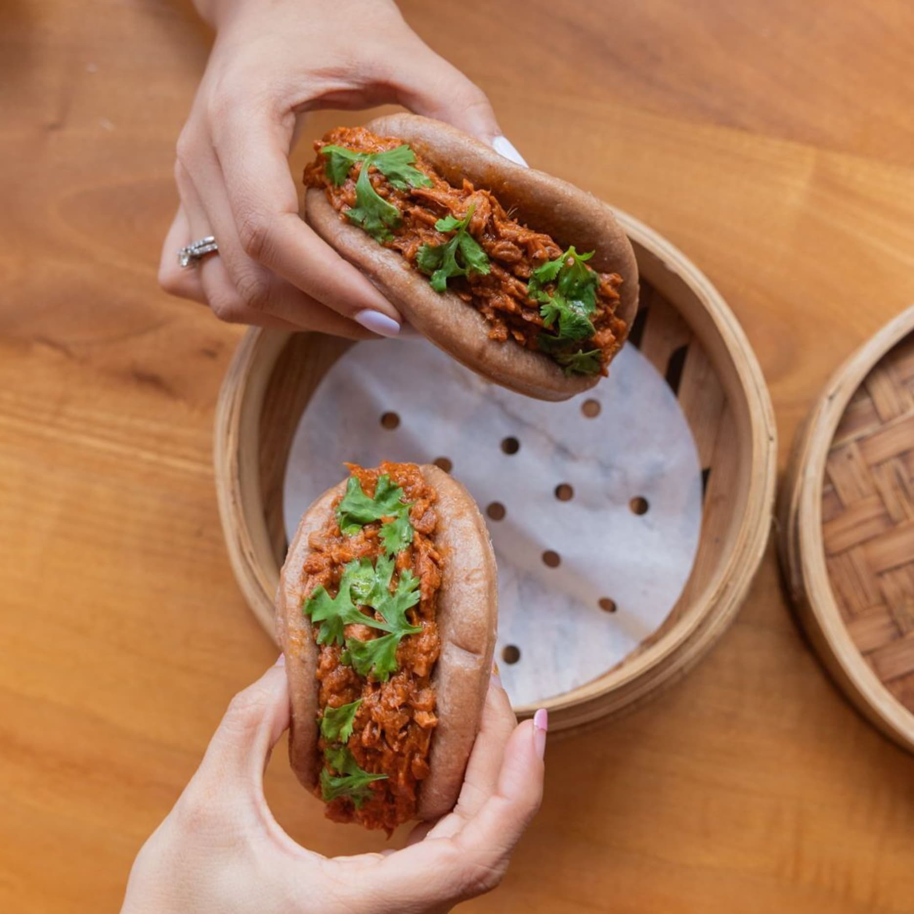 A vegan food Jackfruit Bao with soft multigrain buns, spicy sambal jackfruit filling and crisp fried onions, ready to share.