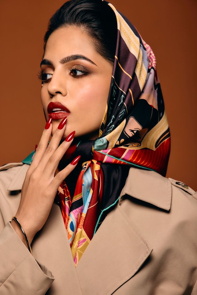 View of the French countryside through a stone villa’s open living room, with sofas and trees framing the scene
