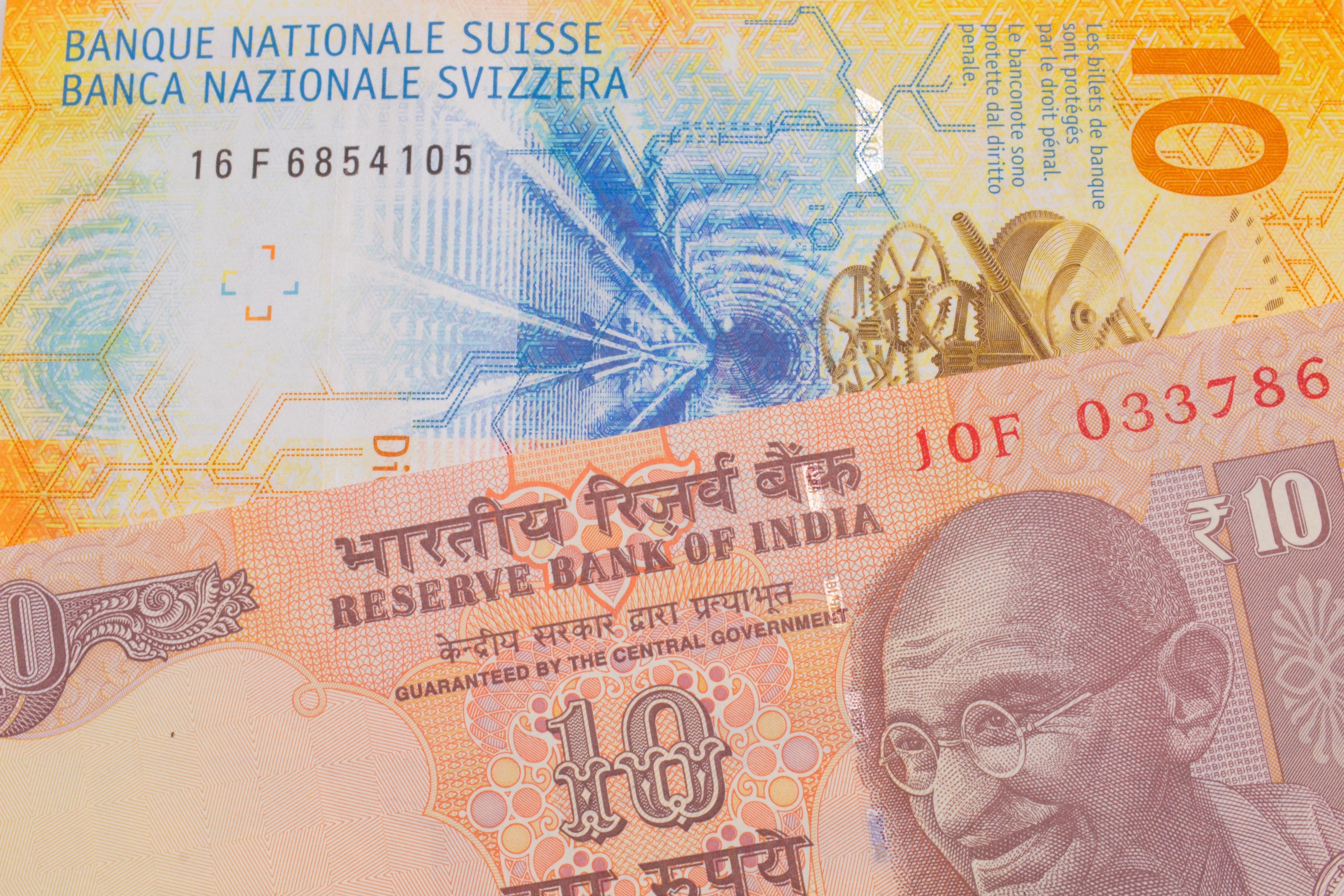 Billets de 10 francs suisses et de 10 roupies indiennes.
