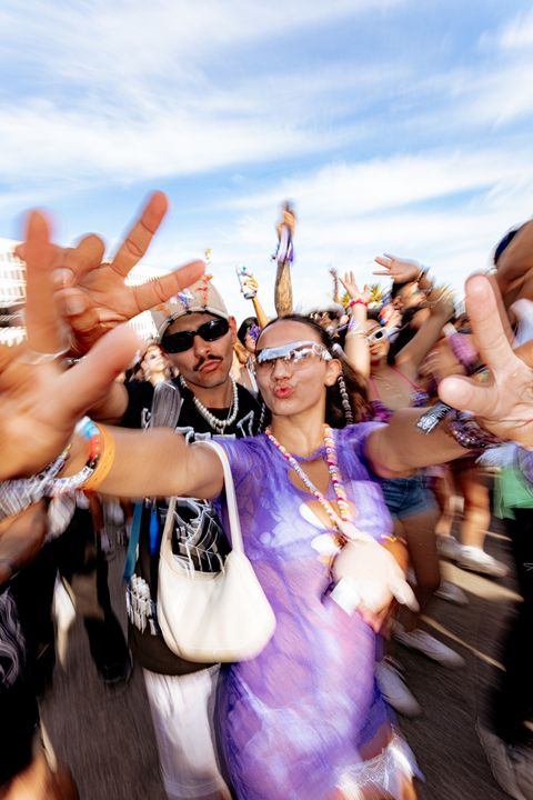 A diverse crowd of people dancing and raising their hands at an event.