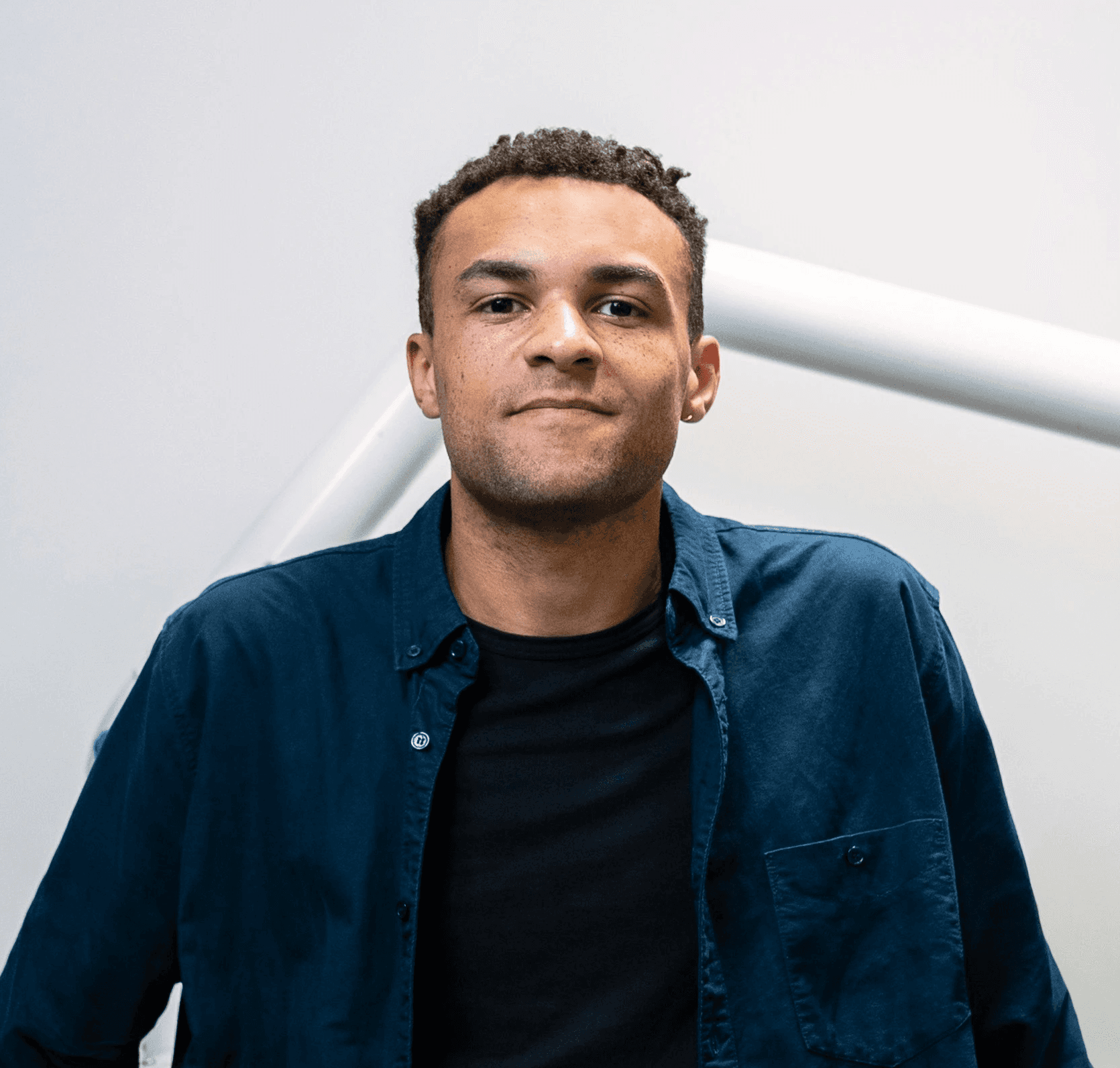 man in blue dress shirt and black dress pants standing beside brown wooden table