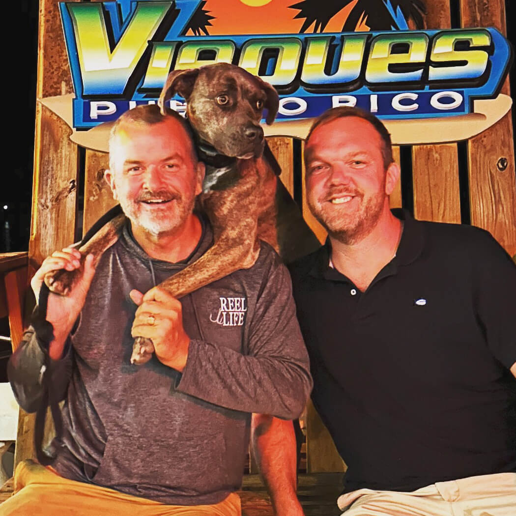 Paul and Sean, hosts of Club Vieques, with their dog in Esperanza, a vibrant town in Vieques, showcasing the friendly and welcoming vibe of this boutique gay resort.