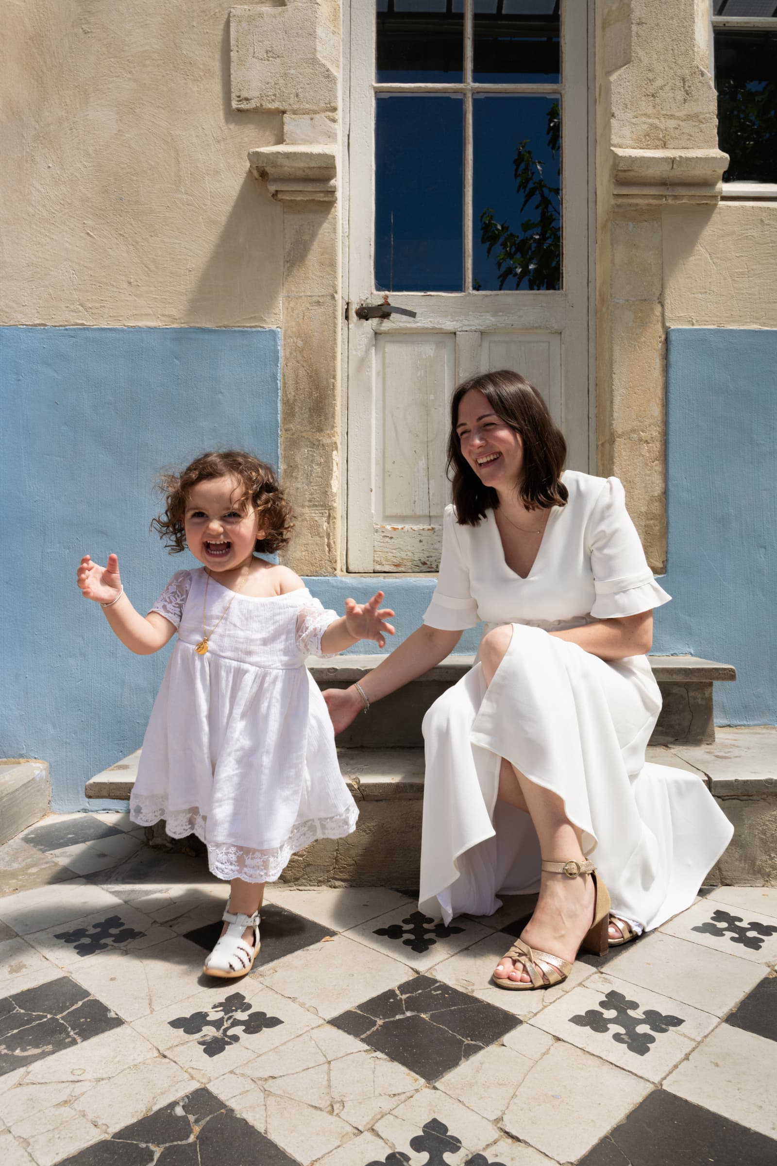 Photo d’une maman et de sa petite fille joyeuse et tendre lors de son Baptême à nimes