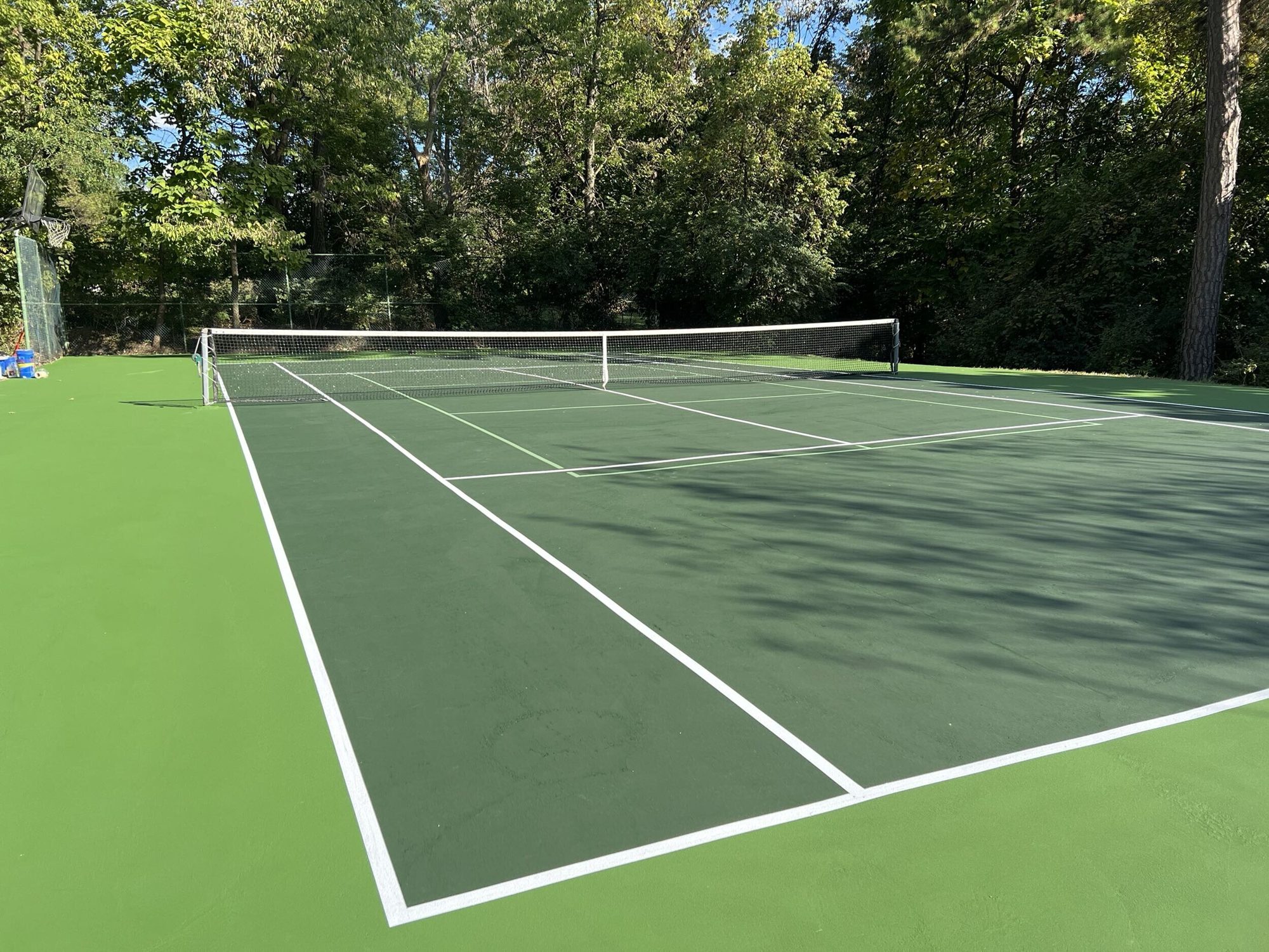Resurfaced home tennis court with a new net and white tennis lines in Cincinnati, OH