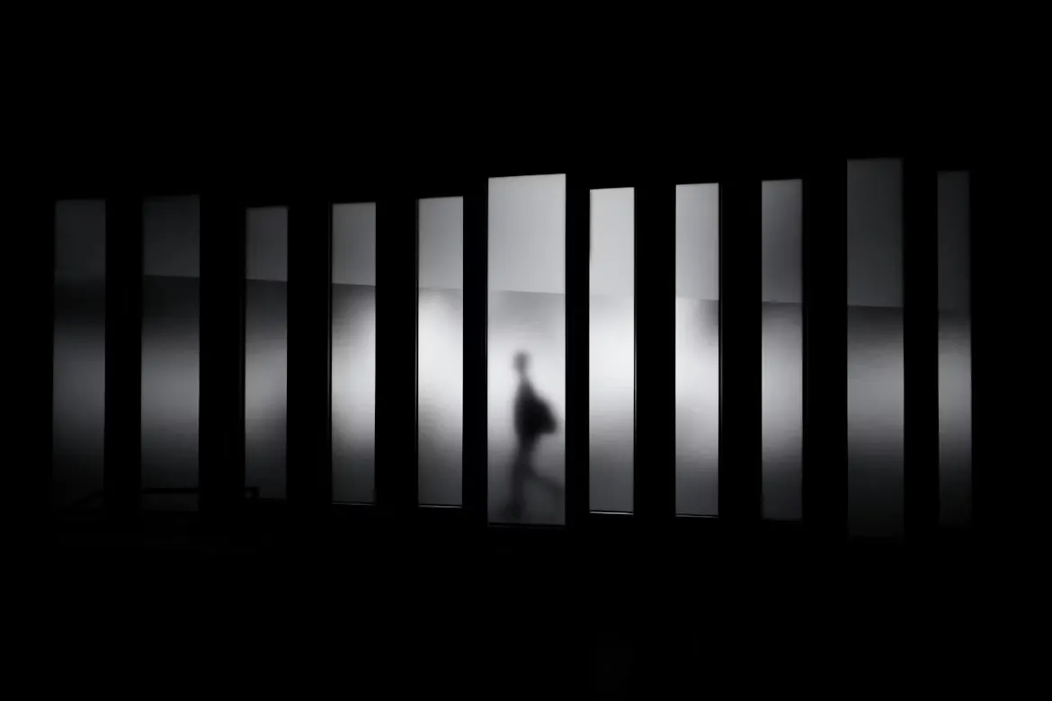 Shadows of people beneath the blurred light and shadow of the glass