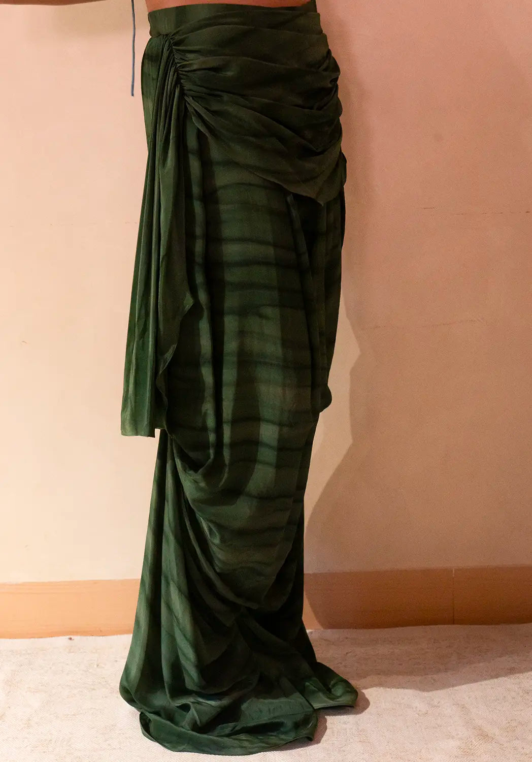 They feature asymmetrical tucks and fluid folds pinned at varying levels,