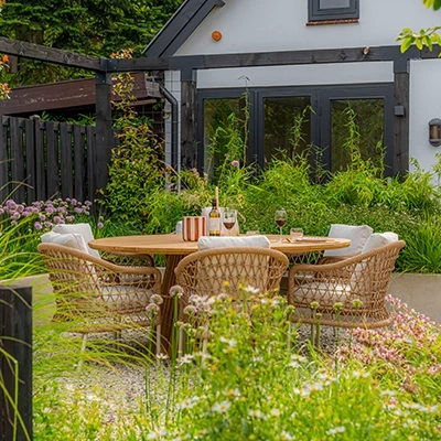 Outdoor garden furniture set from Bali COCO in a lush garden setting.