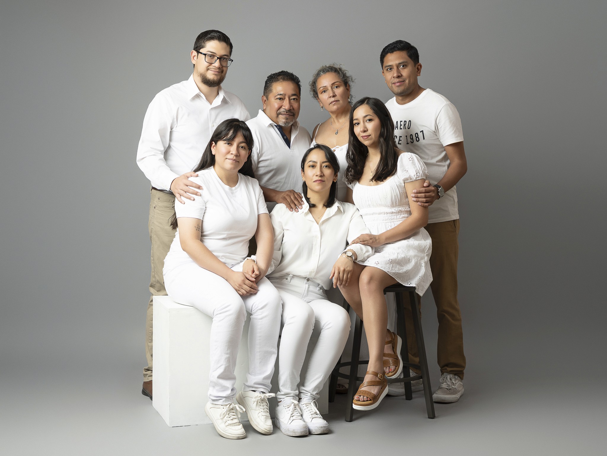 padres e hijos juntos en una sesión familiar en estudio fotográfico