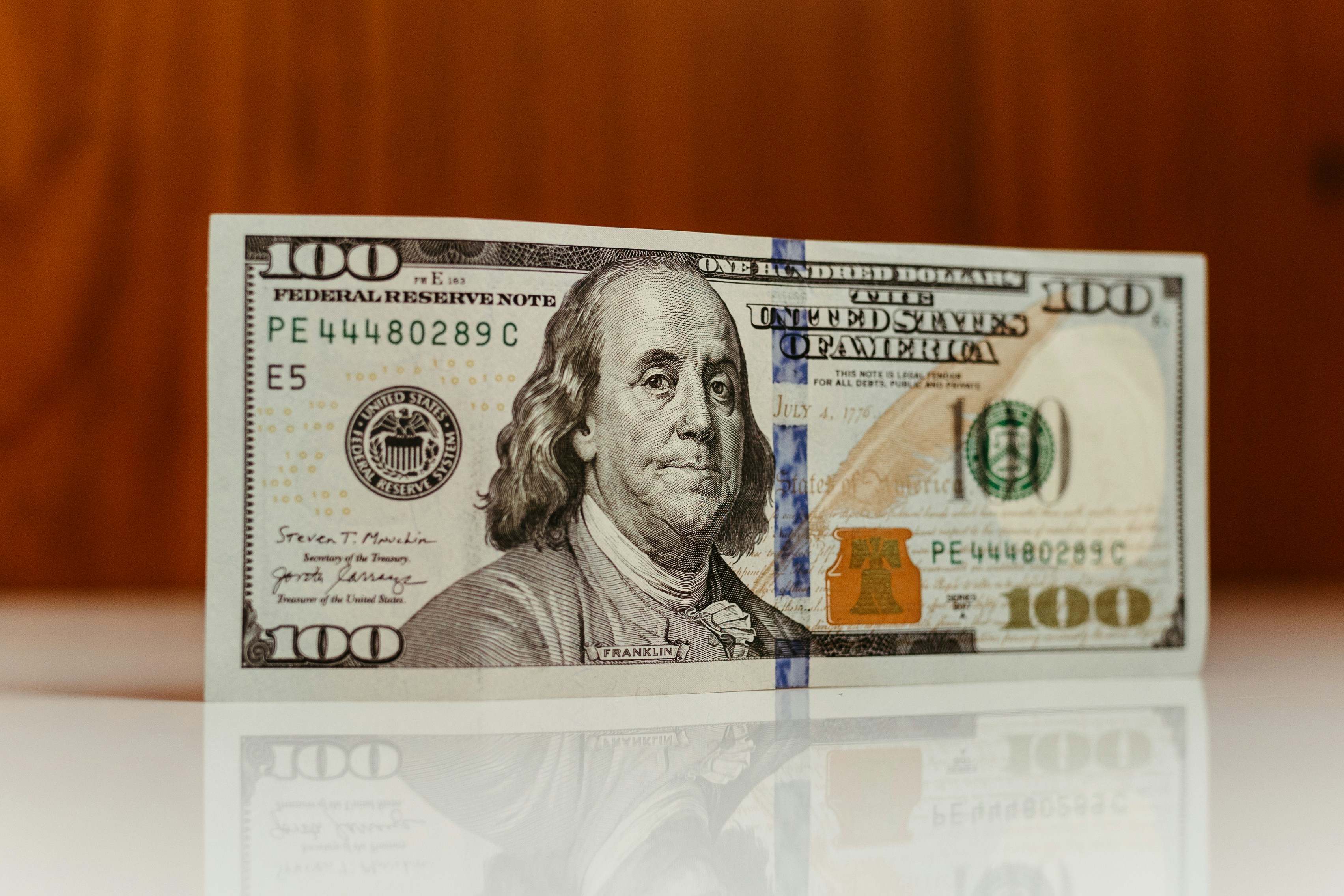 a one hundred dollar bill sitting on top of a table