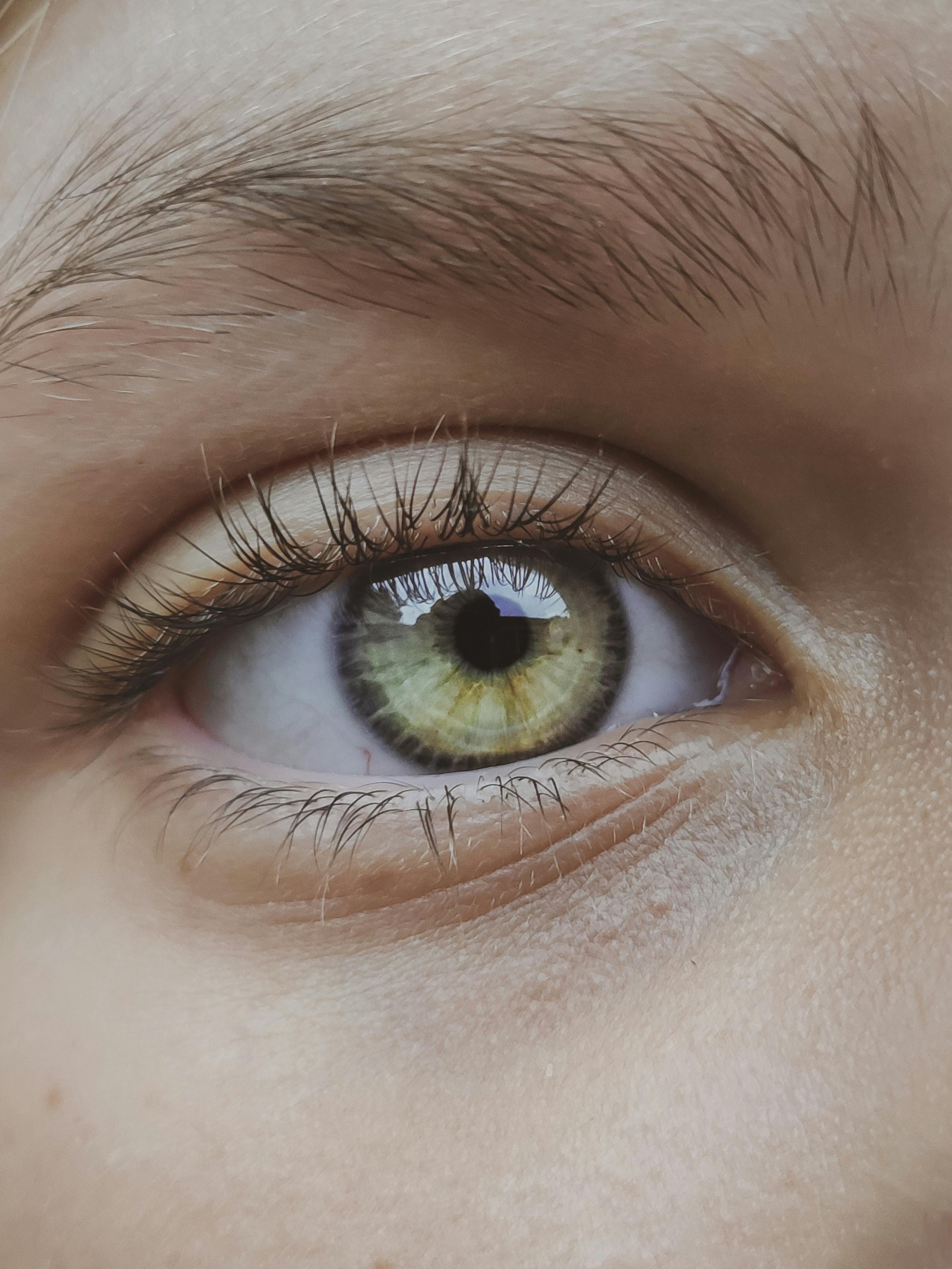 A close-up of a woman wearing a bright red feather top demonstrates the super-high-resolution photographic capabilities of iPhone 17 Pro
