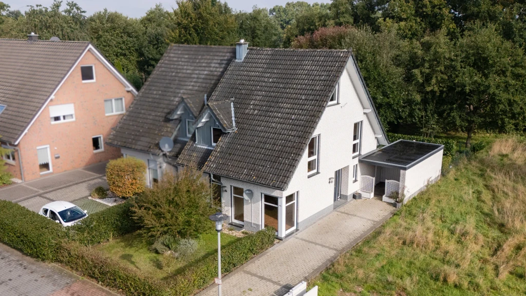 Luftaufnahme des modernen Einfamilienhauses mit Carport und Garten in Heek-Nienborg, Westfalen Wohnen.