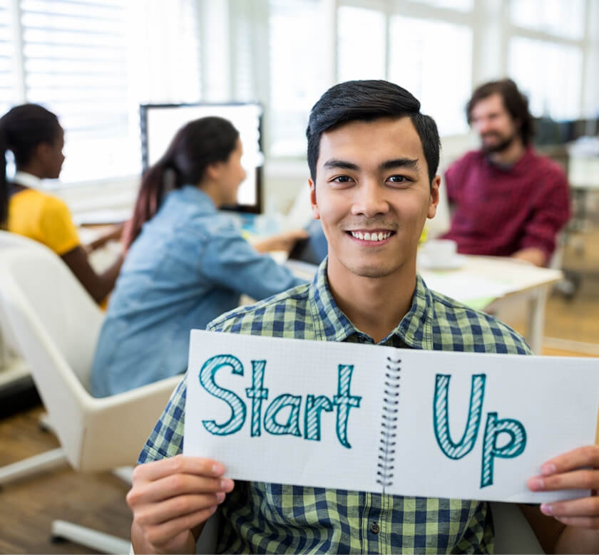 Person holding a sign that says Start Up