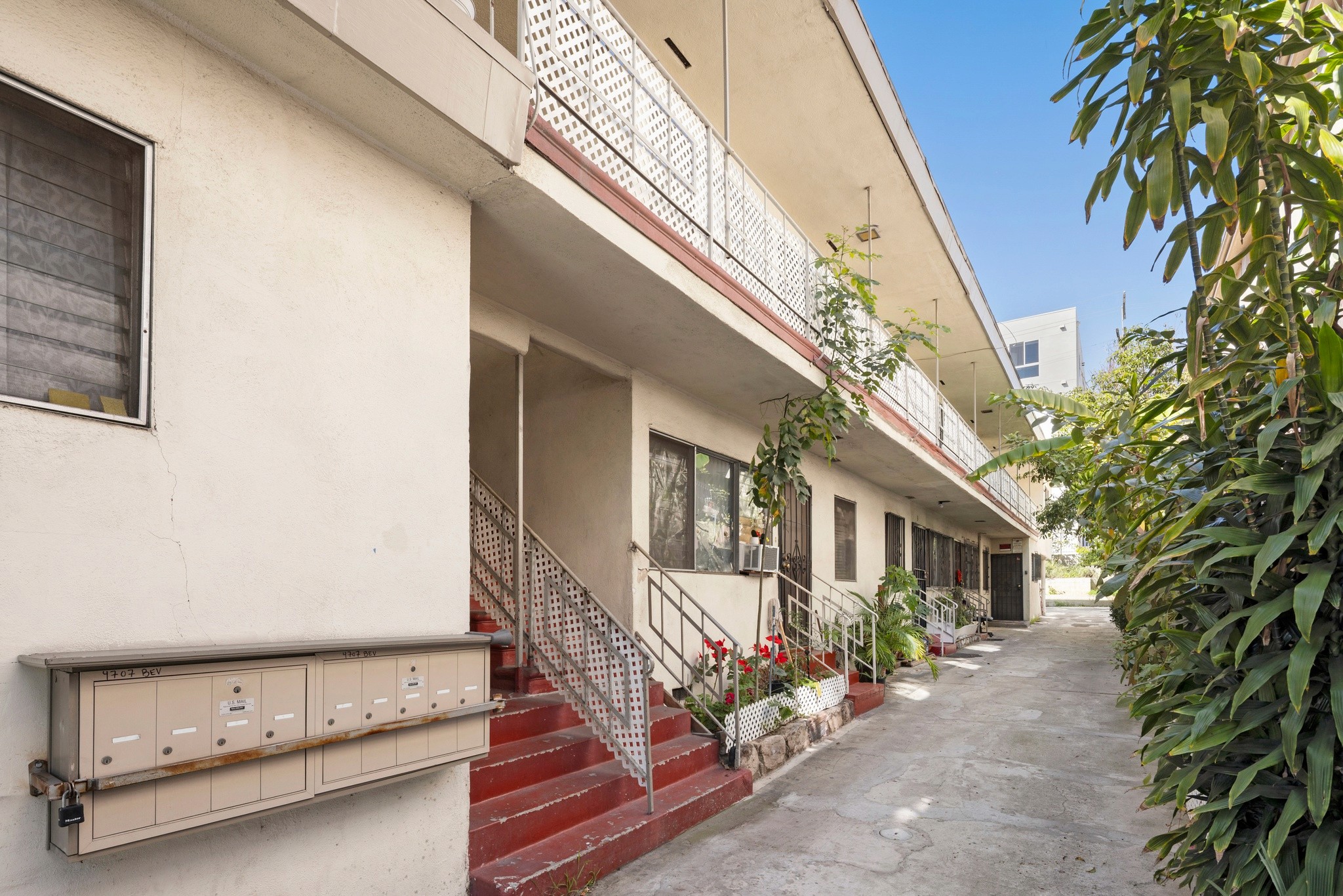 Interior courtyard walkway with stairs, mailboxes, and unit access at 4707 Beverly.