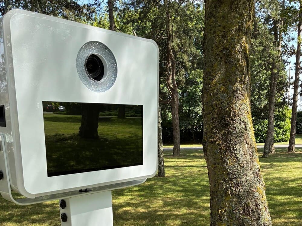 Borne photobooth blanche installée en extérieur dans un parc, location pour mariage et anniversaire dans le Nord