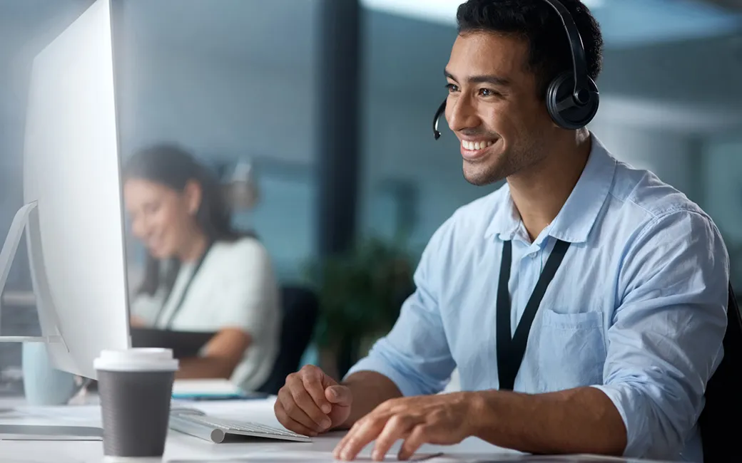 Vriendelijke support medewerker achter een computer