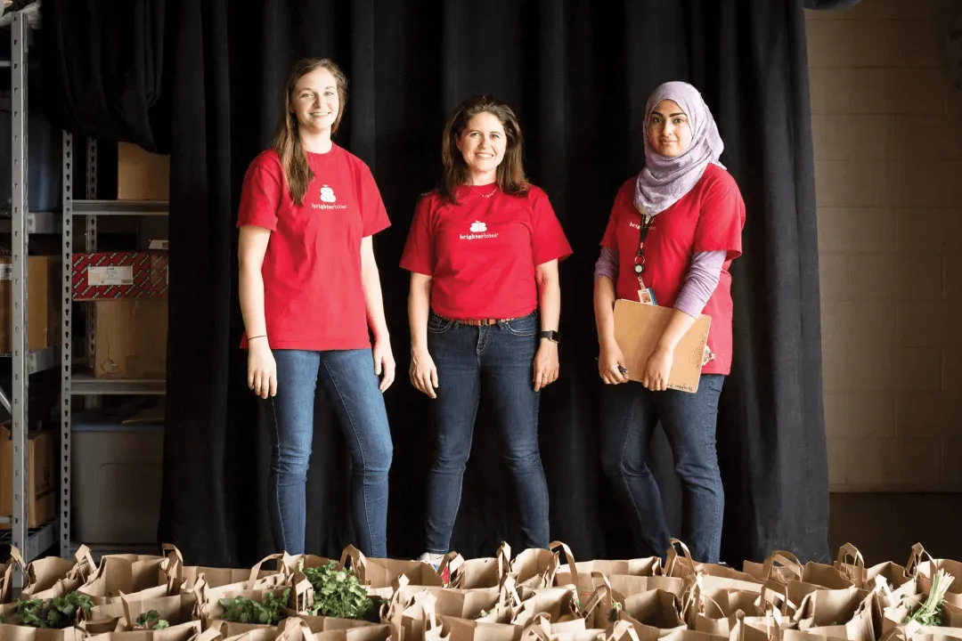 Smiling barista holding green cup at coffee machine