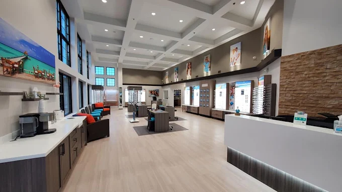 Modern interior of a spacious reception area with large windows, a reception desk, and contemporary design elements.