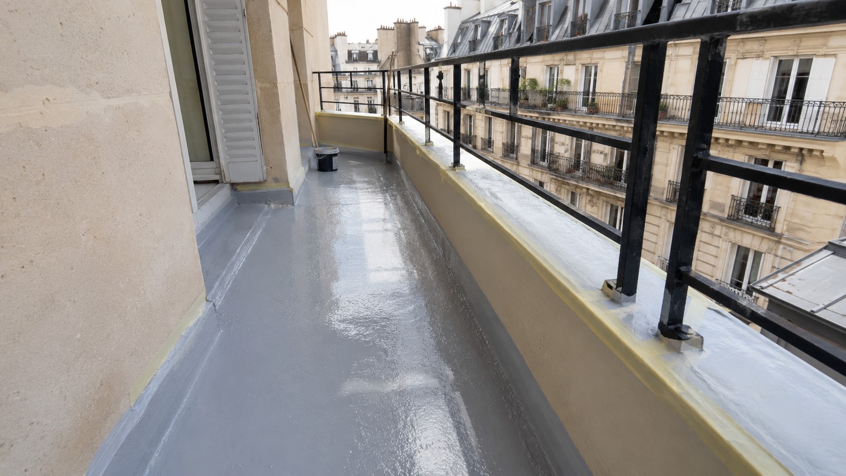 balcon_parisien_copropriete_etancheite_SEL_systeme_etancheite_liquide_resine_grise_fraichement_appliquee_sol_releves_peripheriques_seuil_mur_acrotere_pieds_garde_corps_ruban_masquage_seau_chantier_facades_haussmanniennes_toits_zinc_paris_soleil_aout_2026