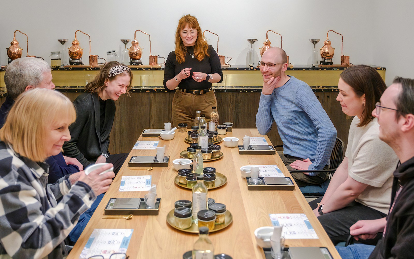 Guests participating in gin making experience with host in Edinburgh distillery.