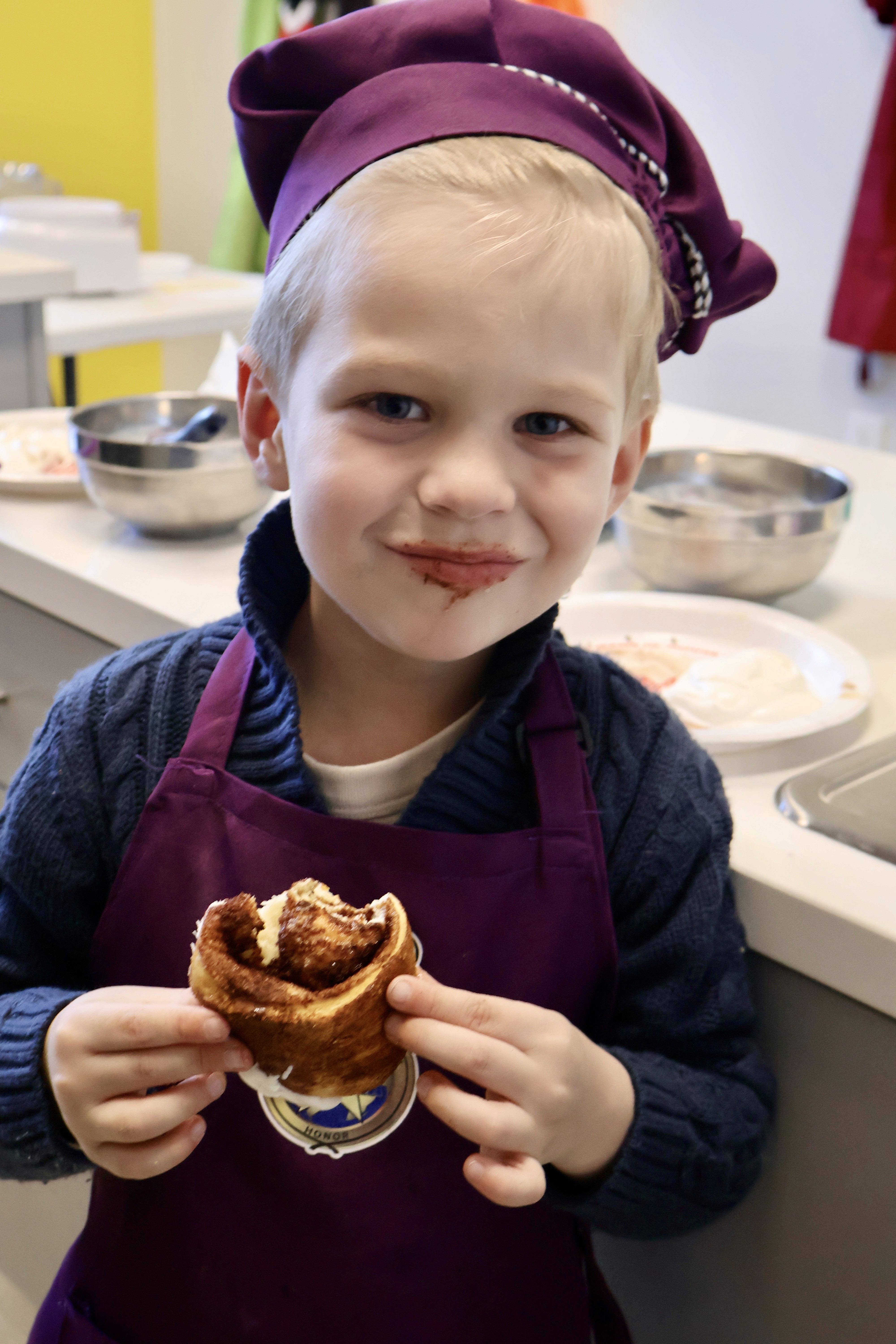 Girls smiling at camera holding a cupcake.