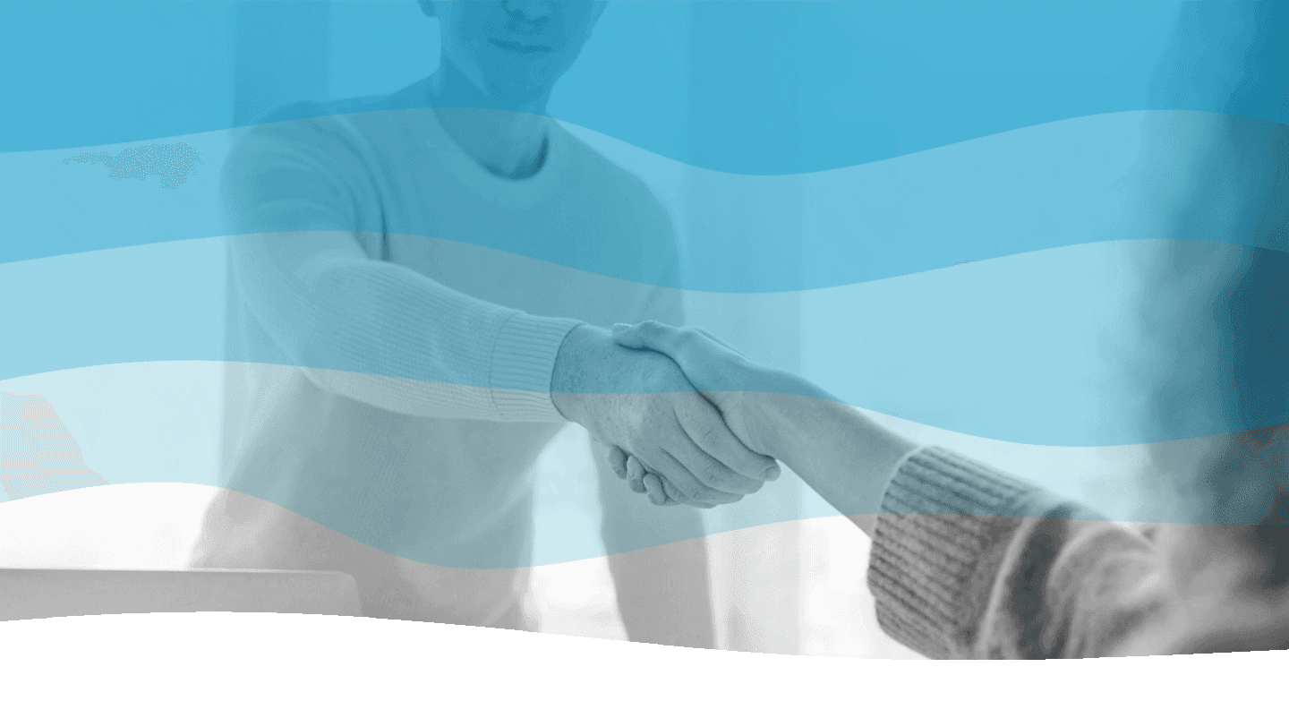 A professional handshake takes place in a modern office setting, symbolizing agreement and collaboration in business.