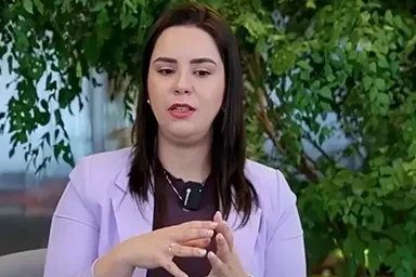 Três pessoas conversam ao ar livre, cercadas por plantas verdes e uma atmosfera relaxante.