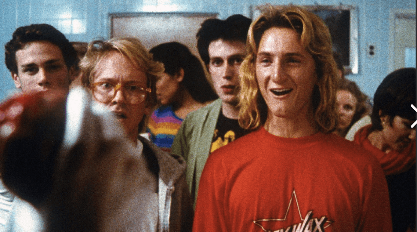 Sean Penn as Jeff Spicoli wearing sex wax t-shirt smiling in class