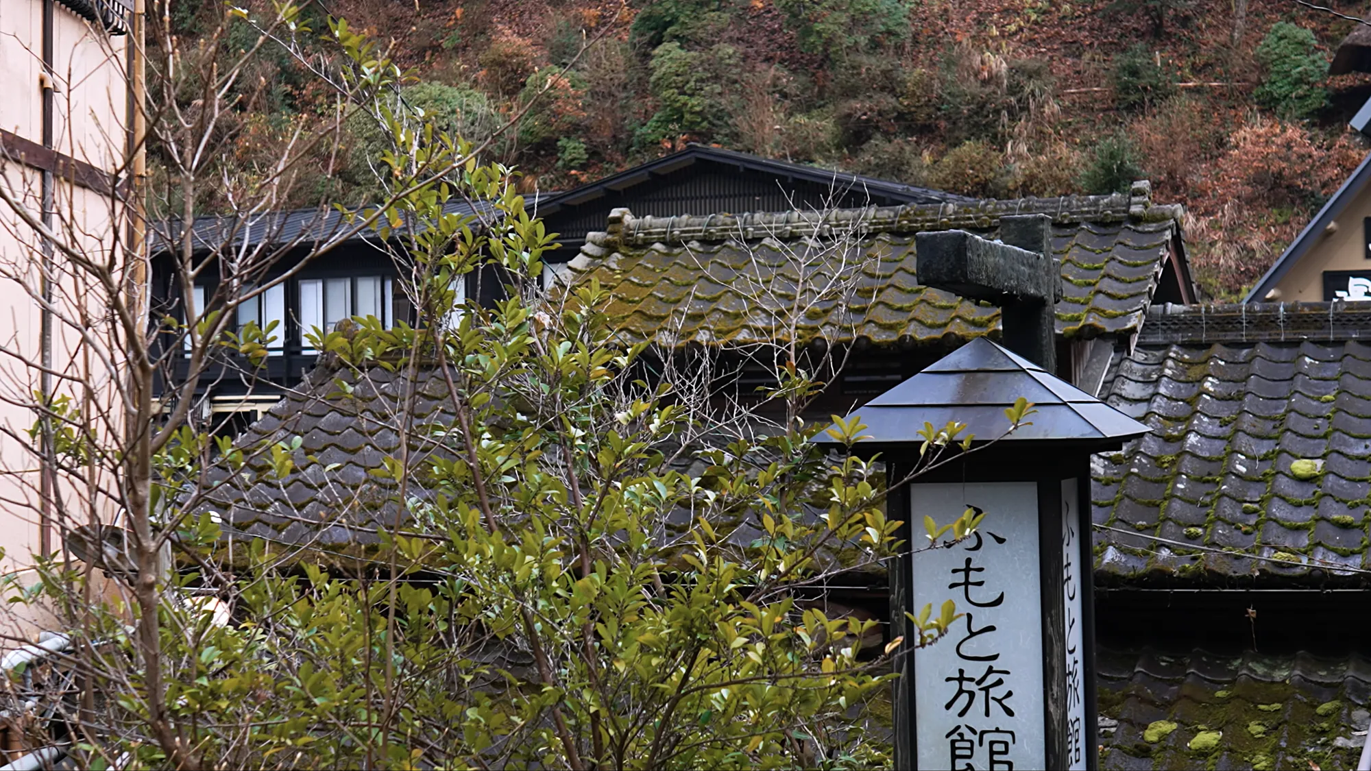 The hanging signboard of Fumoto Ryokan at Kurokawa Onsen, among tiled roofs