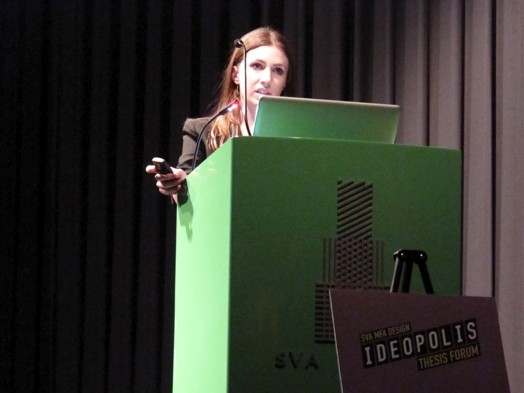 a woman dressed formally is giving a speech from a stand