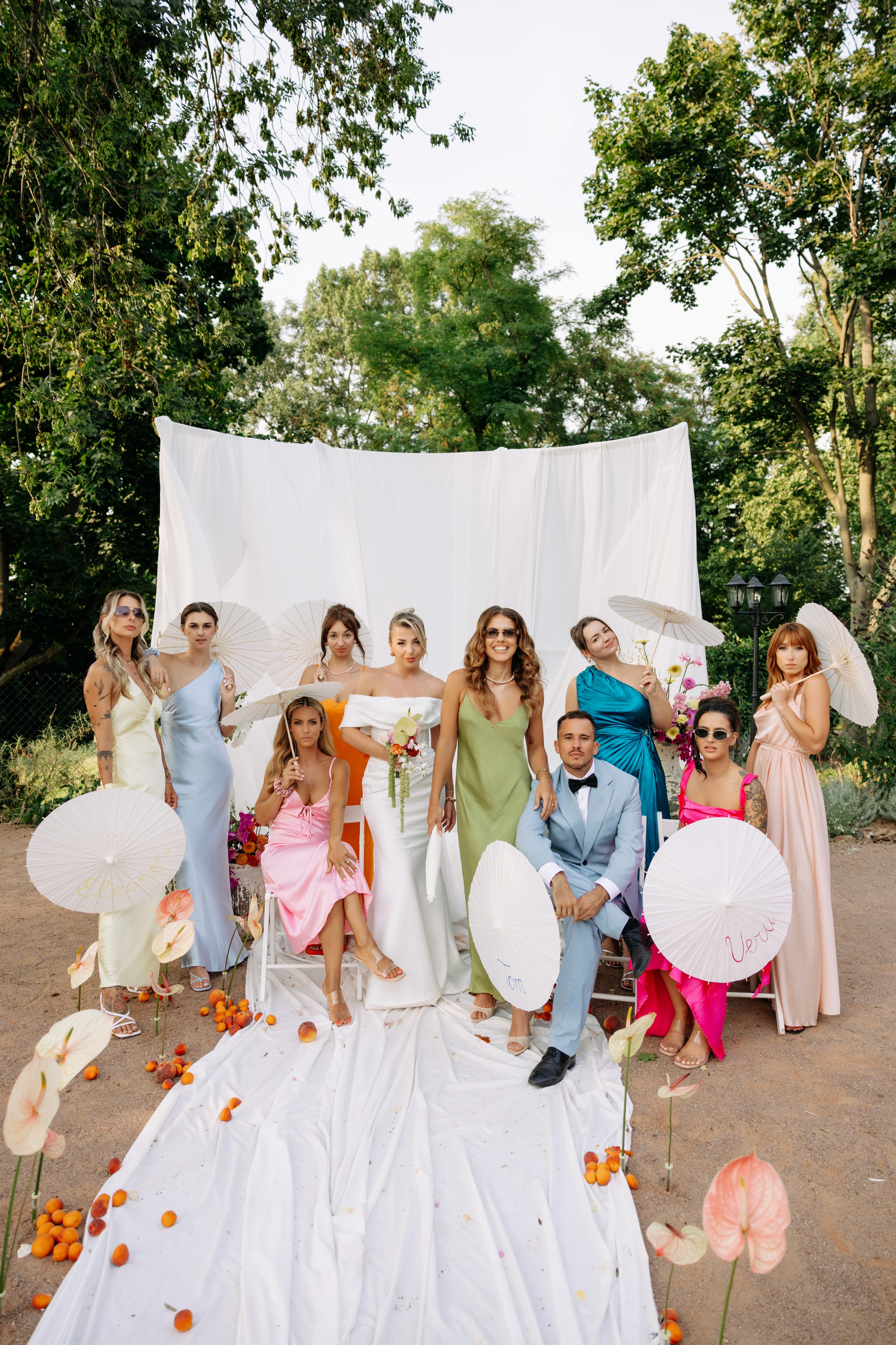 Bridesmaids in vibrant dresses gathered for a joyful portrait — lively and playful.