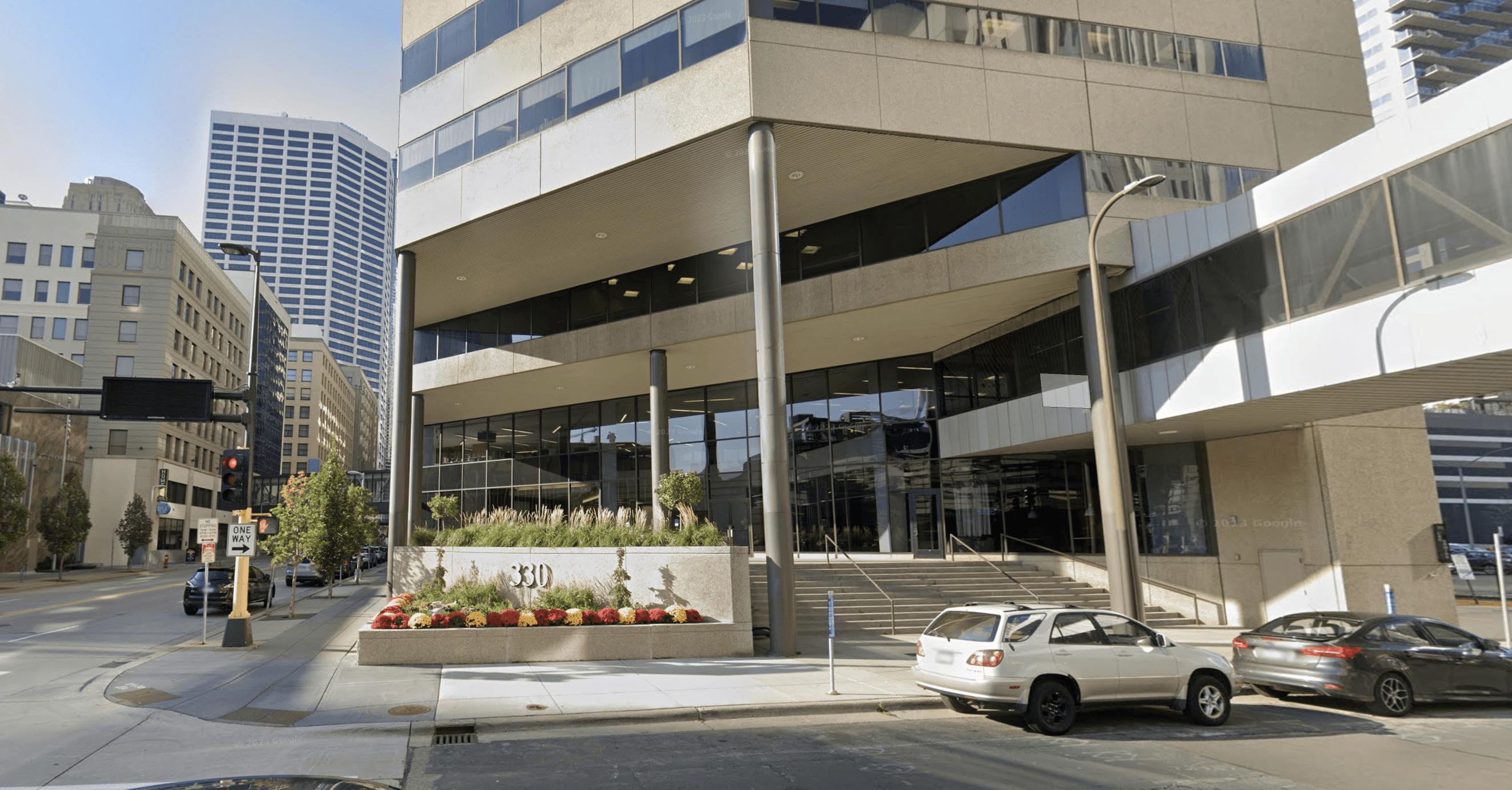 Restored brick building with arched windows and modern glass storefront on a quiet street