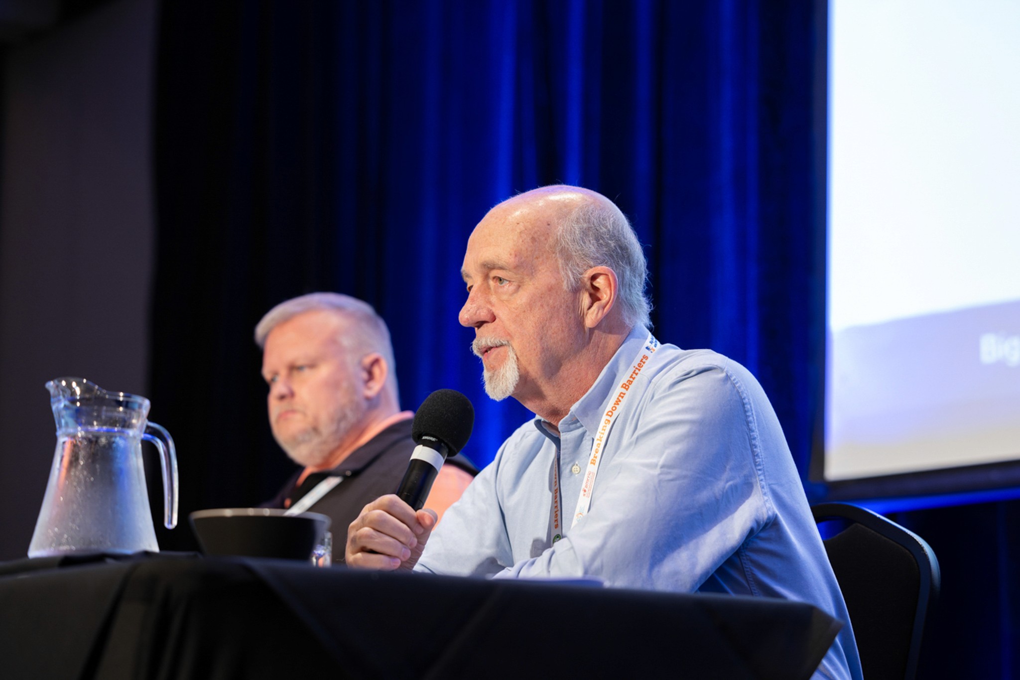 Man speaking into microphone at conference