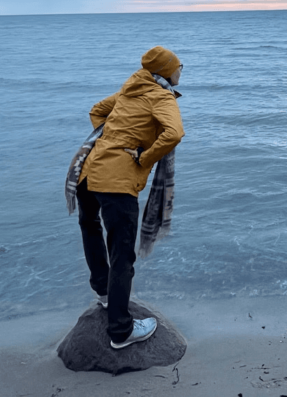 Close-up of a dark green leaf showing its textured surface and central vein against a muted background.