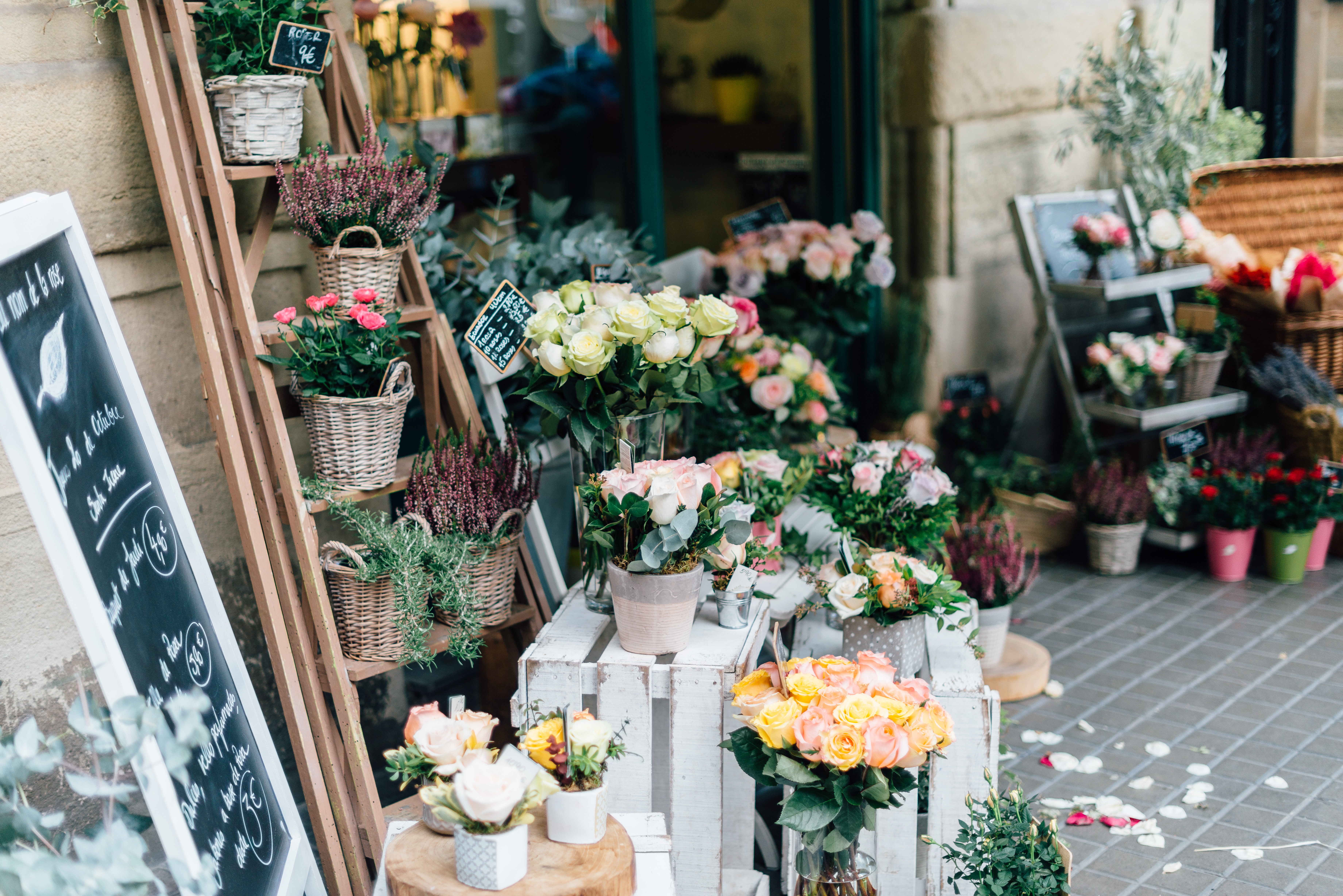 Local florist’s storefront adorned with colorful flower arrangements and decorative chalkboard signage