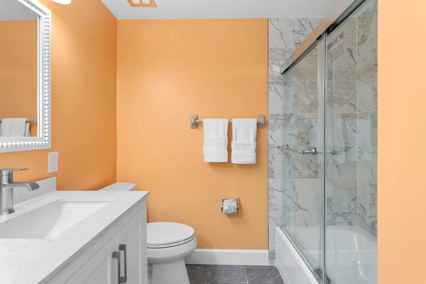 Bath with orange walls and glass shower at Private Backyard Resort, Bradenton, Florida