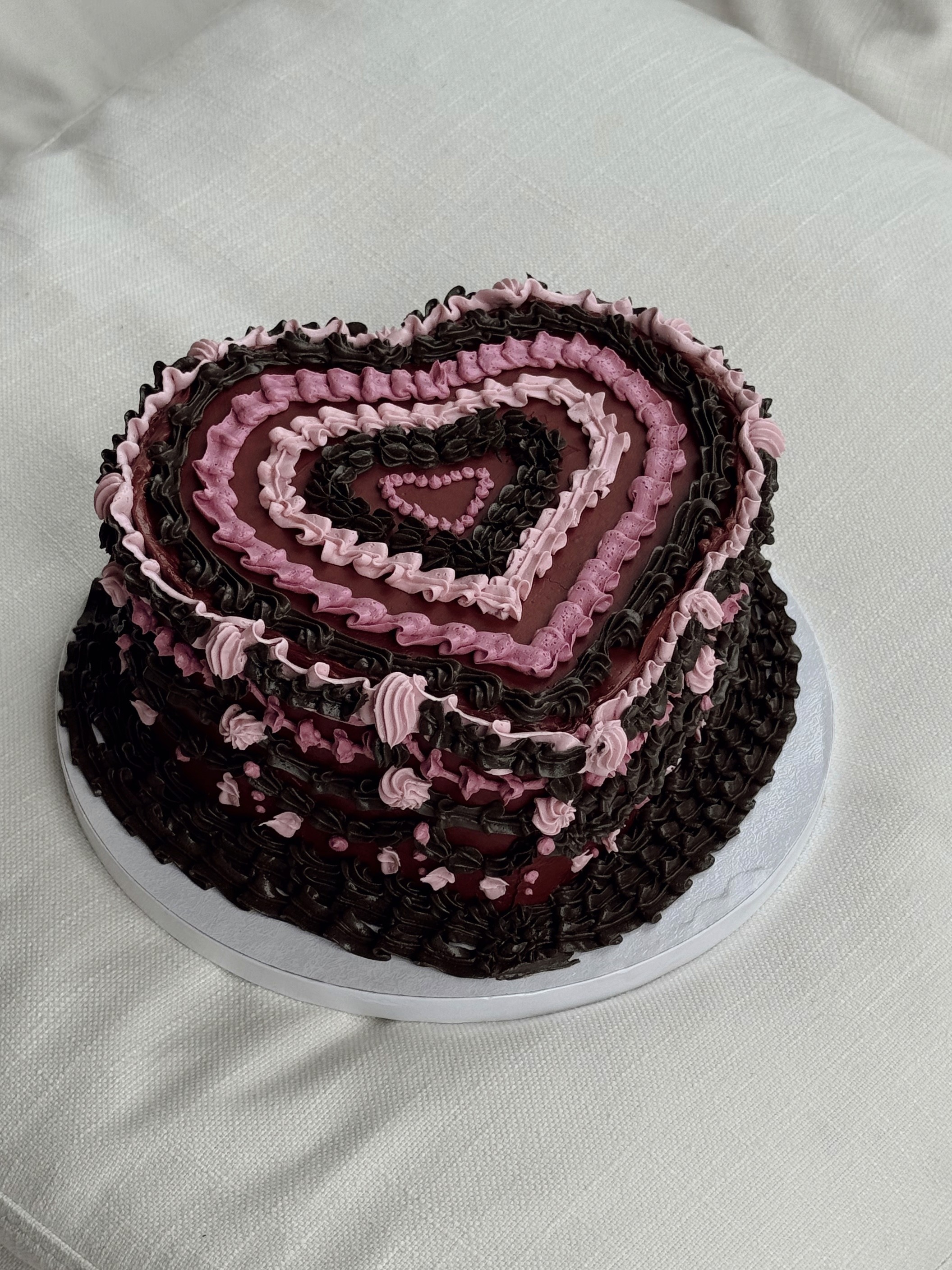Heart-shaped chocolate cake with layered pink and burgundy vintage piping