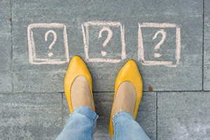 woman with feet in front of question marks on ground