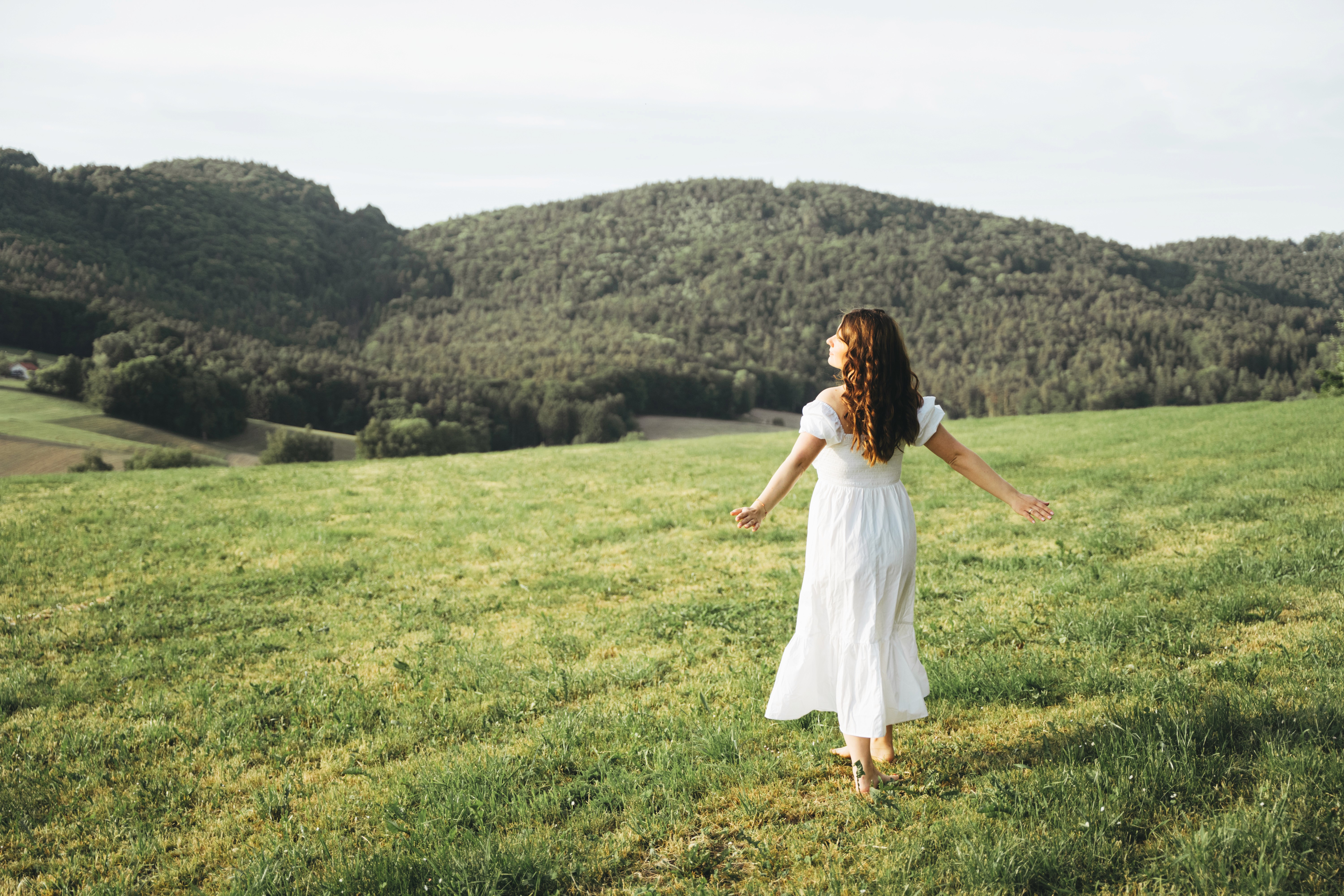 Schwangerschaftsfotografie in Bogen – schwangere Frau im weißen Kleid bei natürlichem Outdoor Shooting.