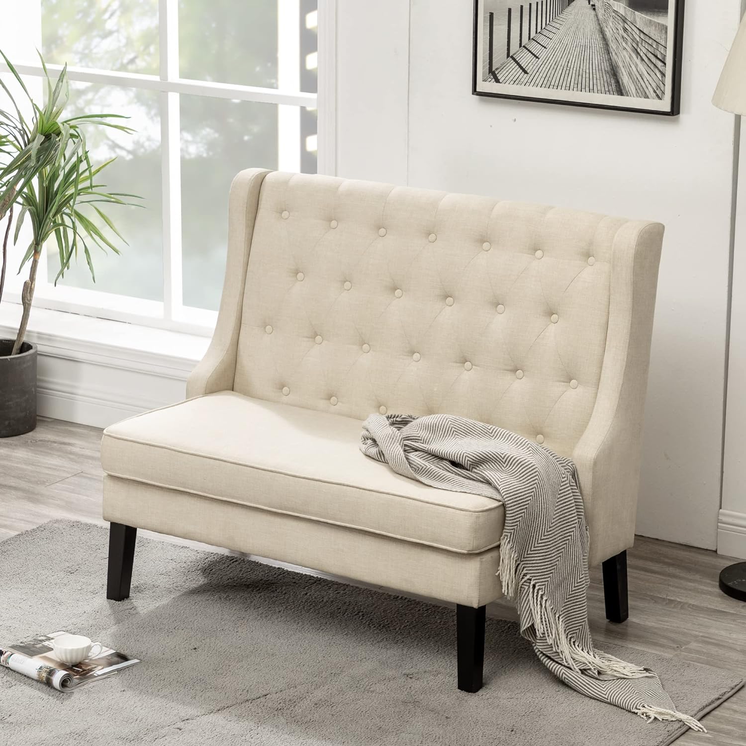 Elegant settee couch with tufted backrest and smooth beige upholstery, offering a classic and compact seating option for small spaces.