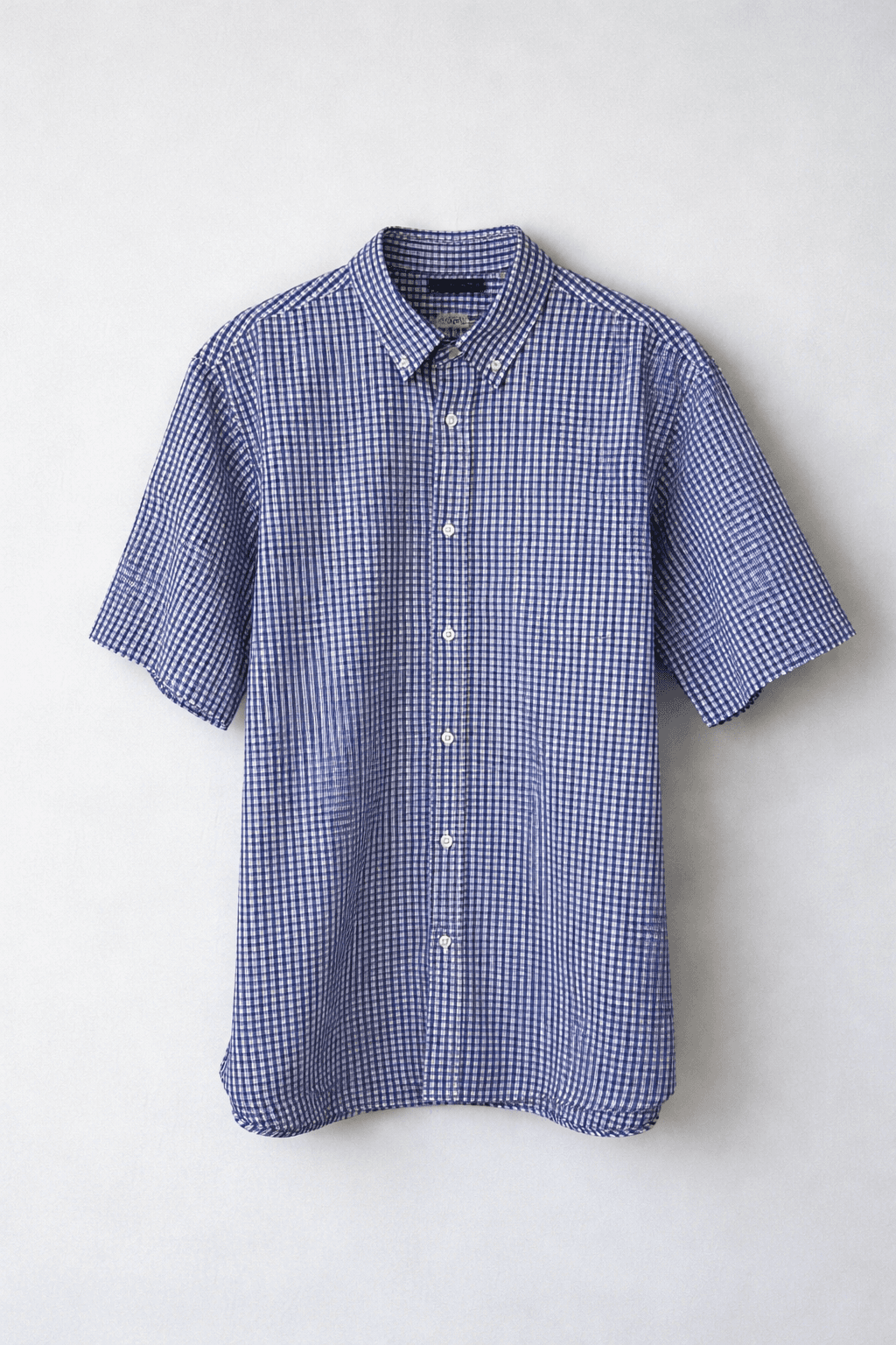 Blue checkered short sleeve button-up shirt on display.