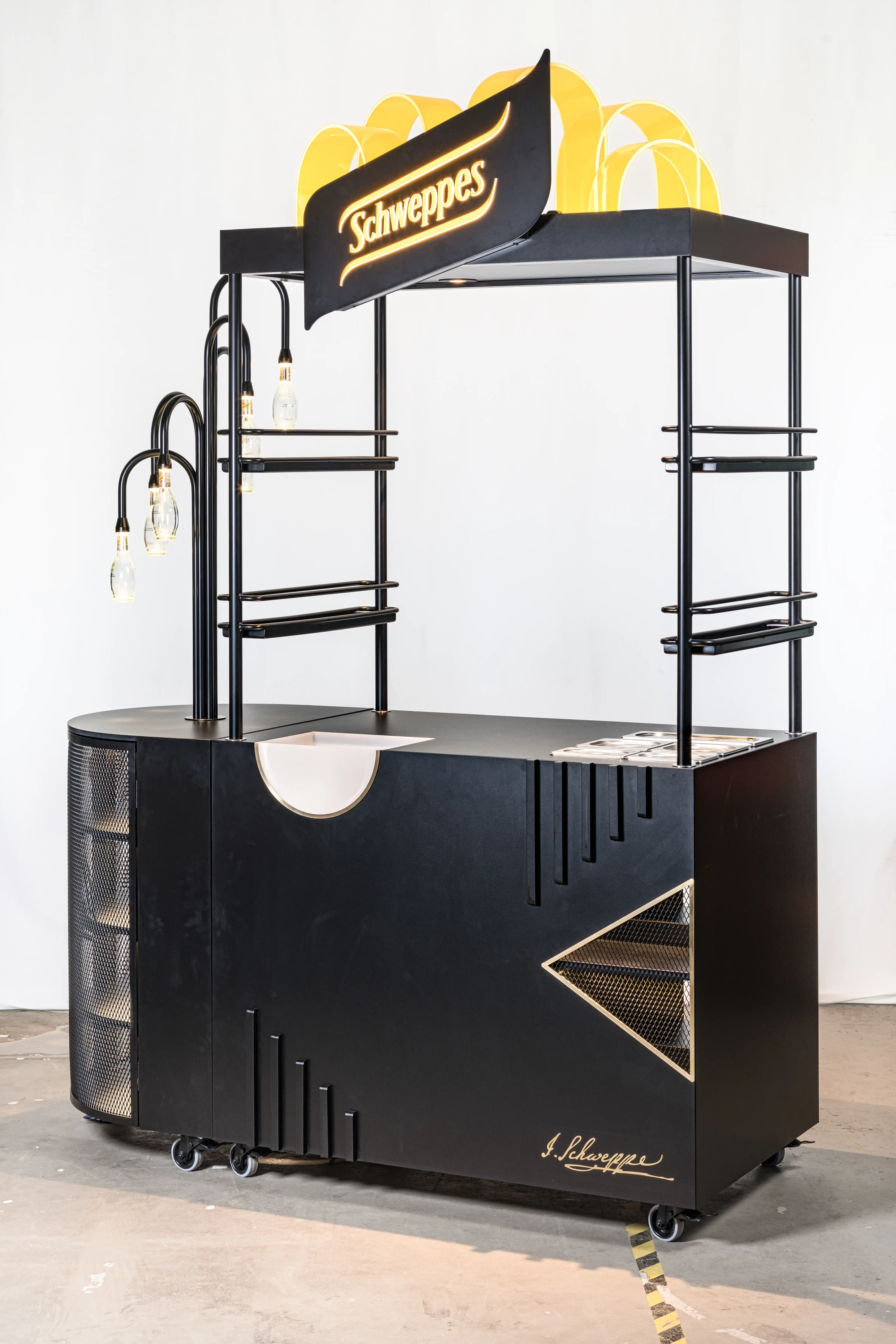 SCHWEPPES bartool with open shelf racks, perforated metal triangle insert, bottle lamps on black arms and an illuminated logo top.