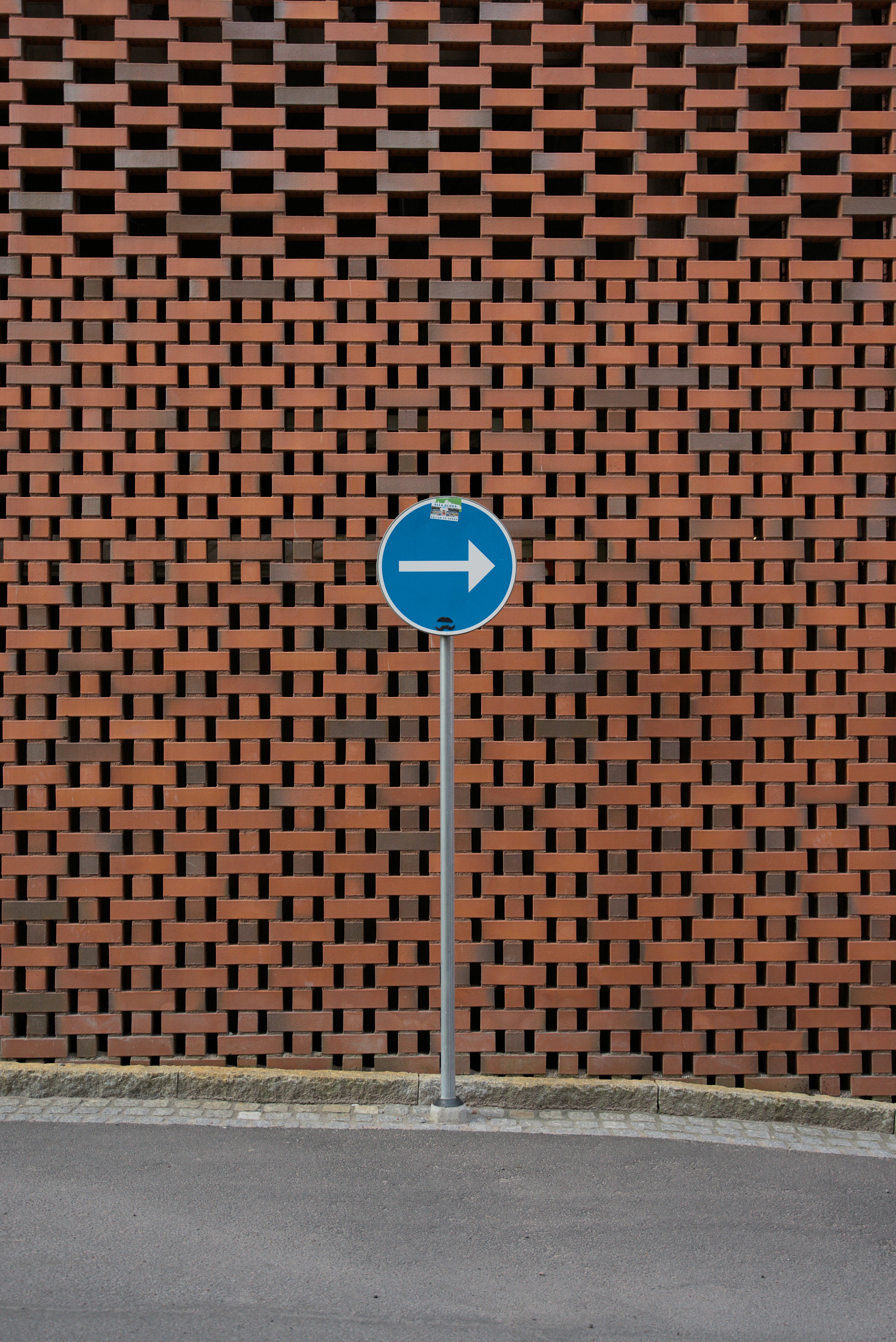 a blue street sign sitting next to a brick wall