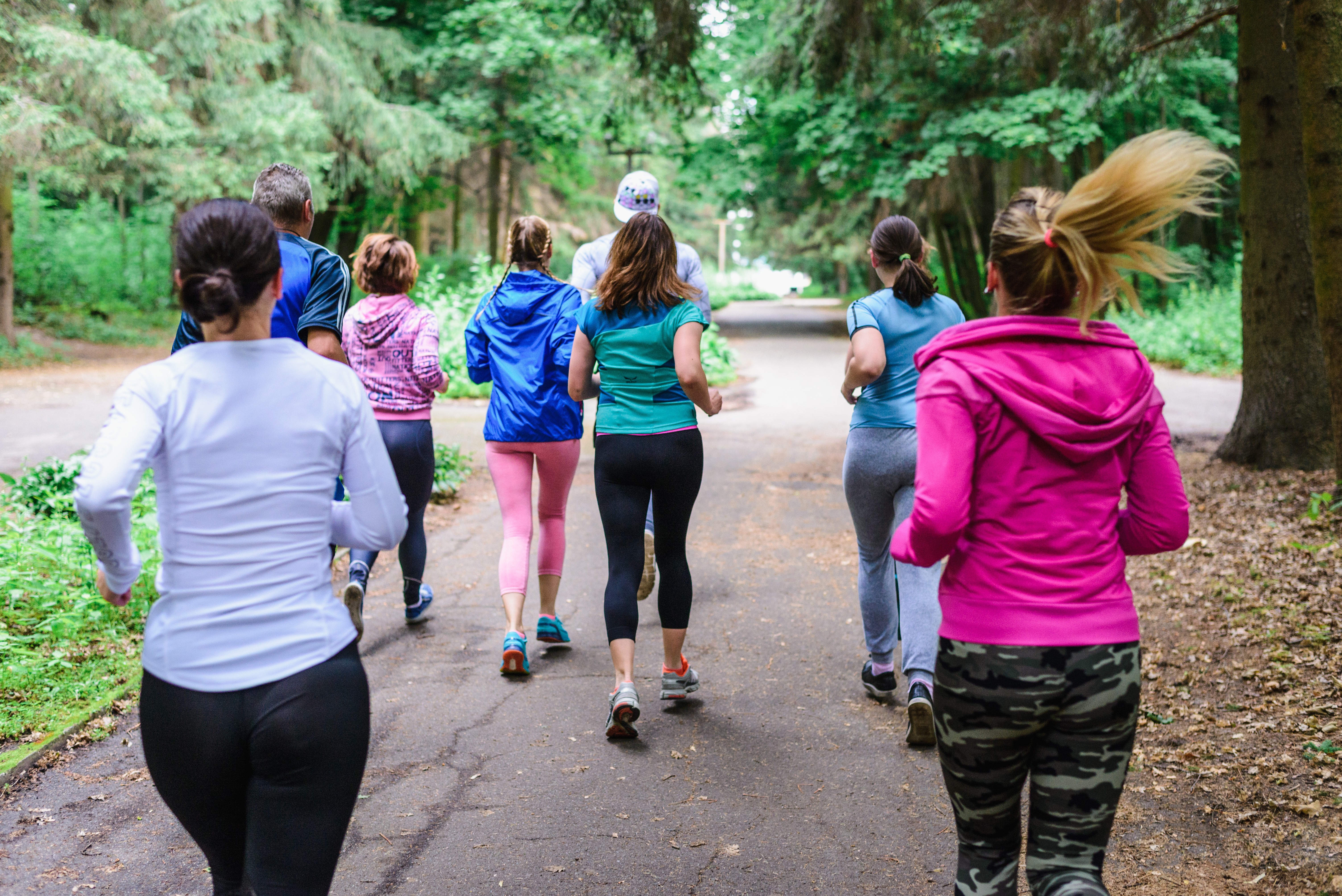 four person hands wrap around shoulders while looking at sunset