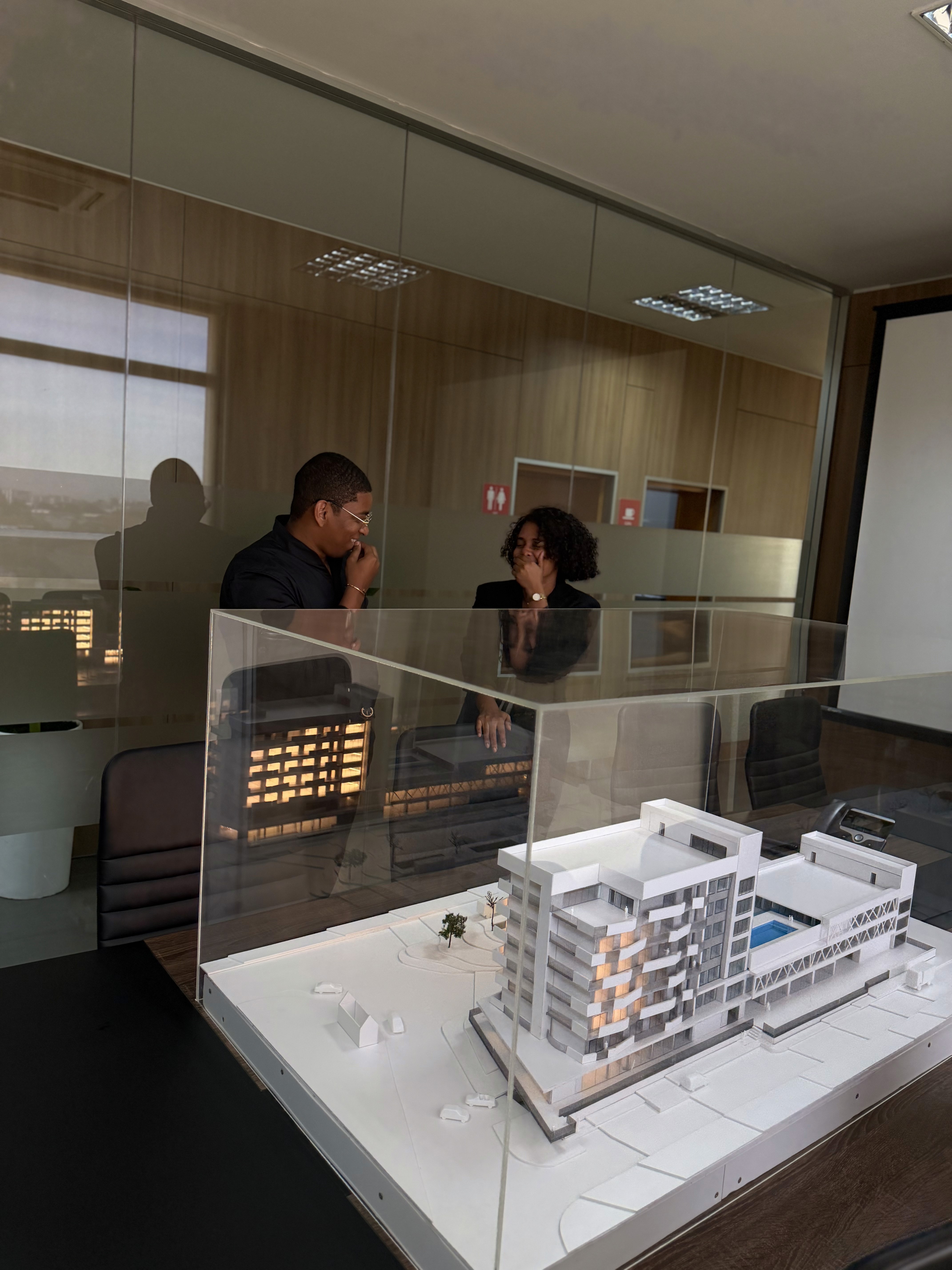 A model of the condominium depicting a man in black clothes talking to a woman.