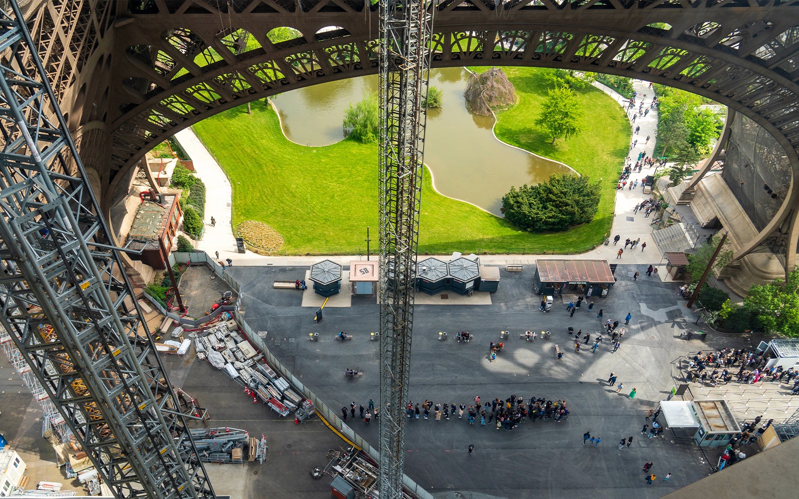 Eiffeltornets utsikt från hissen, som visar basstrukturen och den omgivande parken i Paris.