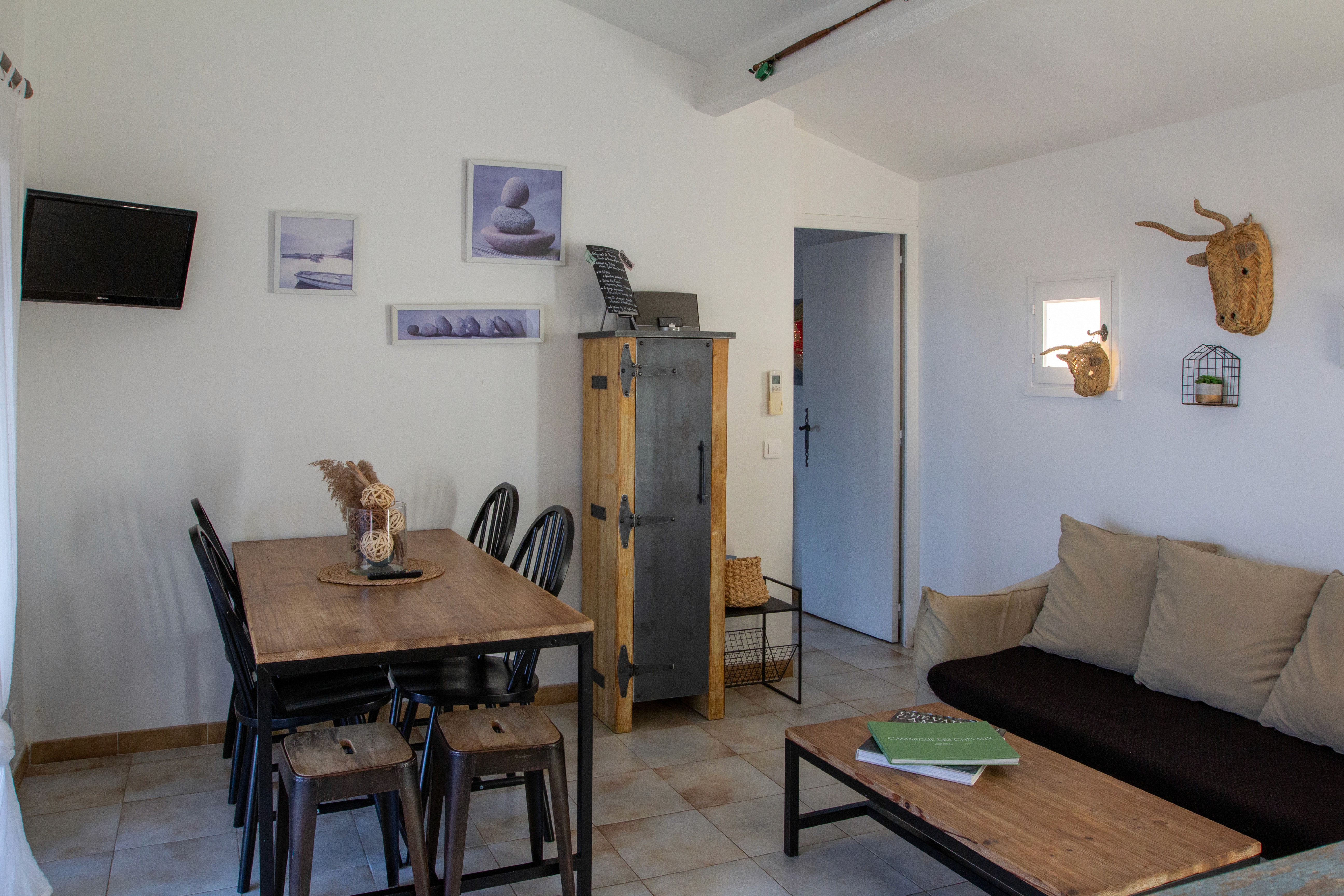 Petite cuisine équipée blanche et bois moderne avec électroménager complet et éclairage sous meuble.