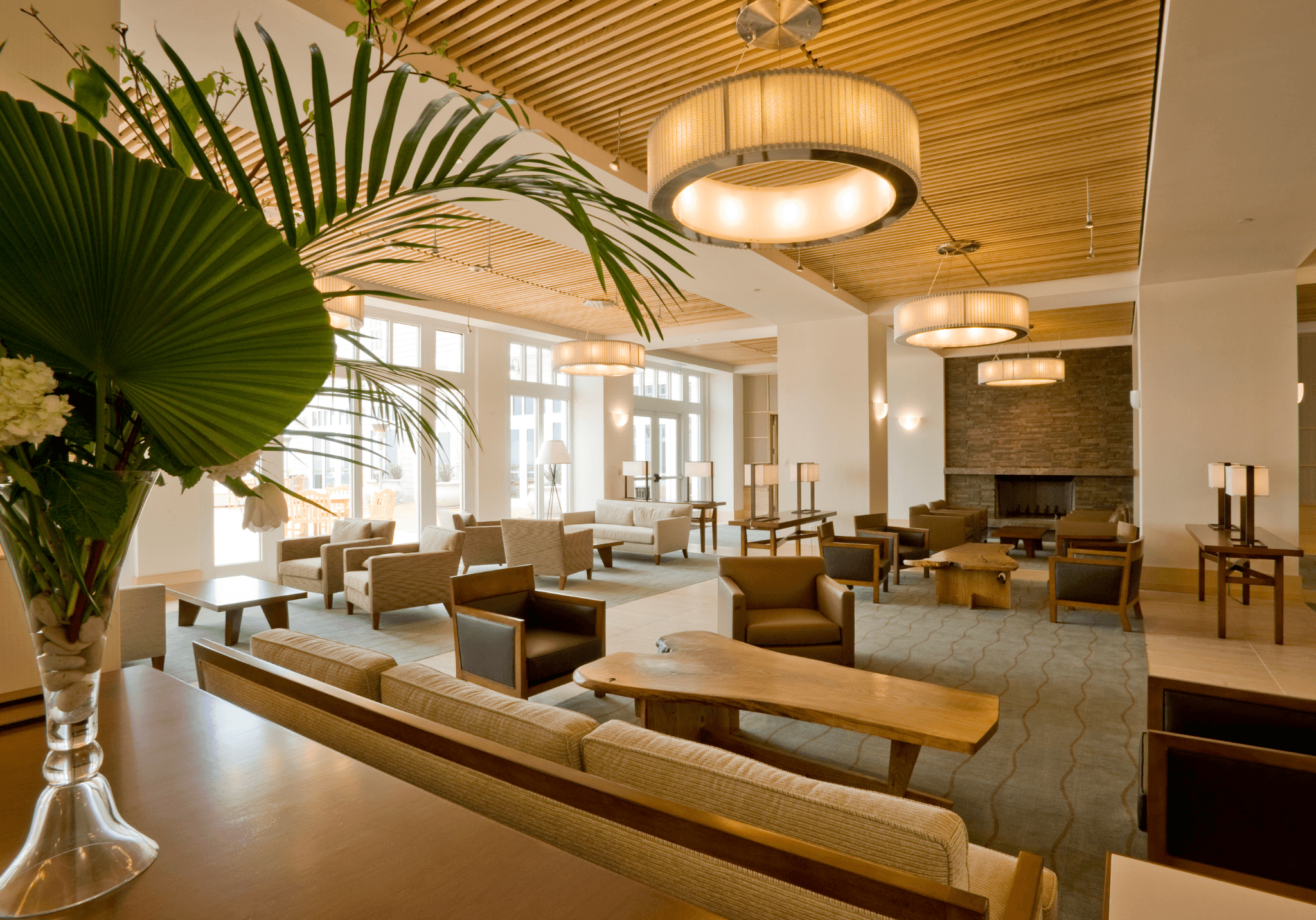 High-end commercial refurbishment of a reception lounge featuring bespoke lighting and wooden ceiling finishes.