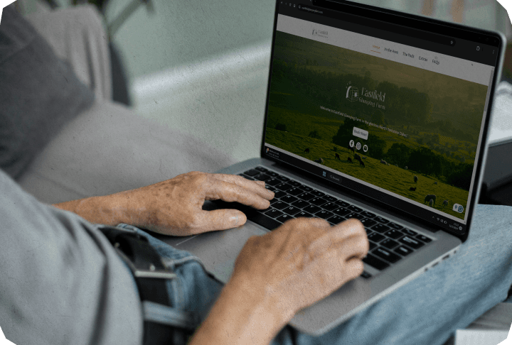 Male checking the Eastfield Glamping Farm website on his laptop