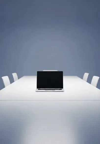 A laptop on the empty conference room table