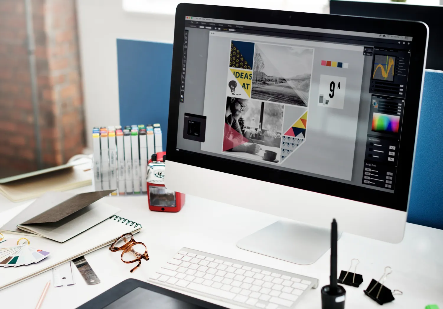 Designer's desk with mood board, colour swatches, and design tools on screen